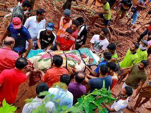 Rescue workers shift a body from the debris left after a landslide at Kavalappara in Malappuram district, Kerala.