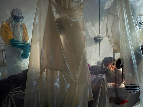File photo: Health workers wearing protective gear check on a patient isolated in a plastic cube at an Ebola treatment center in Beni, Congo.