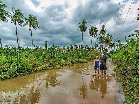 People wade through a flooded area following incessant rainfall in Hampi, Monday, Aug 12, 2019.