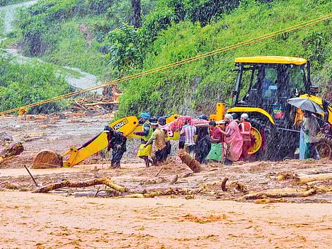 Rescuers carry a victim of a landslide caused by torrential monsoon rains in Meppadi in Wayanad district, Kerala.