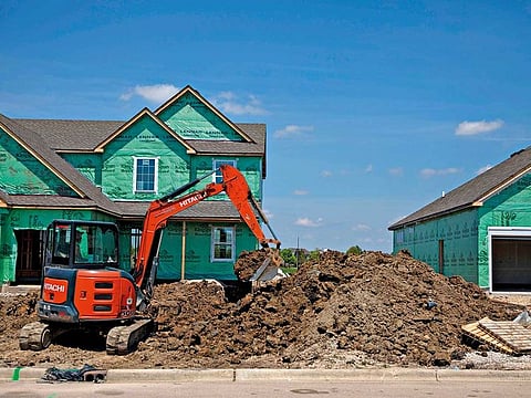 A worker operates a Hitachi Construction Machinery Co. excavator to dig a trench outside a new home under construction at a Lennar Corp. development in Montgomery, Illinois, U.S.