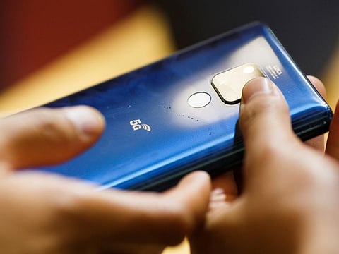 A man holds a Huawei 5G smartphone at the International Consumer Electronics Expo in Beijing, China