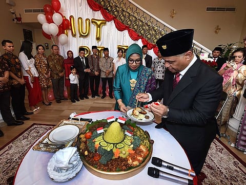 Ridwan Hassan, Indonesian Consul General to the UAE during the cutting the Nasi Tumpeng (yellow rice cone).