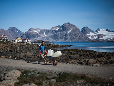 A resident of Kulusuk carts water in the town of Kulusuk, Greenland, on August 16, 2019.