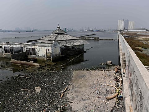 An submerged mosque next to a giant sea wall in northern Jakarta. Indonesia's capital is being swallowed into the ground at such an alarming rate that experts warn much of it could be submerged by 2050.