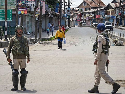 Security personnel stand guard at a check point during restrictions, in Srinagar, Sunday, August 18, 2019. P