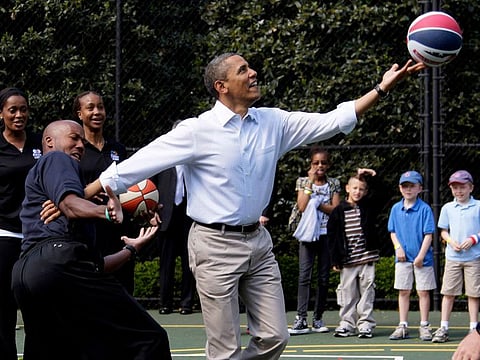 Then-President Barack Obama plays basketball with former NBA basketball player Bruce Bowen during the annual White House Easter Egg Roll at the White House in Washington in 2012.