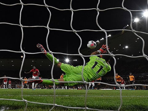 Wolves goalkeeper Rui Patricio (R) saves a penalty from Manchester United midfielder Paul Pogba.