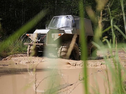 Postwoman Galina Yermolova with her husband drive their homemade off-road vehicle in a forest outside the village of Pikhtovskiy
