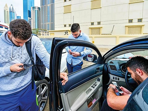 Dubai residents on their smartphones. Industry sources say that multi-purpose apps will define the next level of user experiences. Picture for illustrative purposes only.