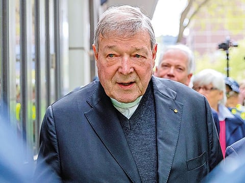 Vatican Treasurer Cardinal George Pell is surrounded by Australian police as he leaves the Melbourne Magistrates Court in Australia, October 6, 2017.