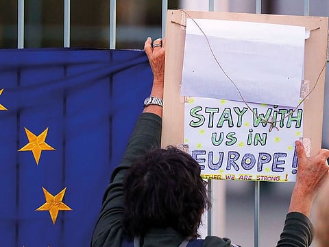 An anti-Brexit protester holds up a placard as Boris Johnson, UK prime minister, meets Angela Merkel, Germany's chancellor, at the Chancellery in Berlin, Germany, on Wednesday.