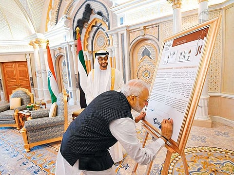 Shaikh Mohammad looks on as Indian PM Modi signs the commemorative stamp of Mahatma Gandhi on his 150th Birth Anniversary.