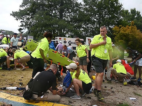 Fans are assisted by medical personnel after a lightning strike during the third round of the Tour Championship golf tournament at East Lake Golf Club.