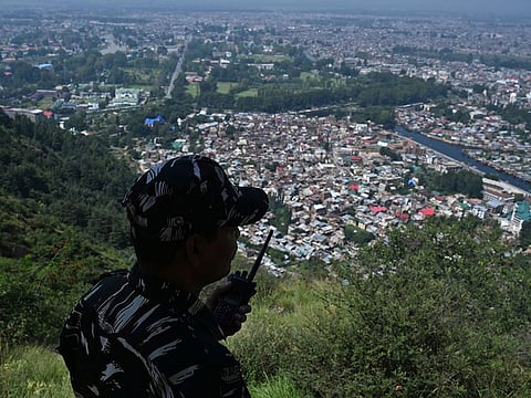 A paramilitary trooper patrols at the top of a hill in Srinagar. Governor Satya Pal Malik says communication curbs helped save many lives.