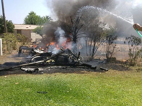 A man sprays water at wreckage on fire after a collision between a helicopter and a light plane that killed at least seven people on the Spanish island of Mallorca August 25, 2019.