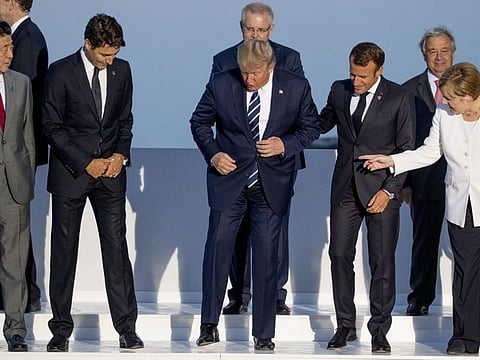 From left, Japanese Prime Minister Shinzo Abe, Canadian Prime Minister Justin Trudeau, US President Donald Trump, French President Emmanuel Macron, German Chancellor Angela Merkel, and others arrive for the G-7 family photo with guests at the G-7 summit at the Hotel du Palais in Biarritz, France, Sunday, Aug. 25, 2019.