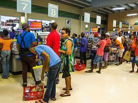 Residents stand in line at a grocery store as they prepare for the arrival of Tropical Storm Dorian, in Bridgetown, Barbados, Monday, Aug. 26, 2019