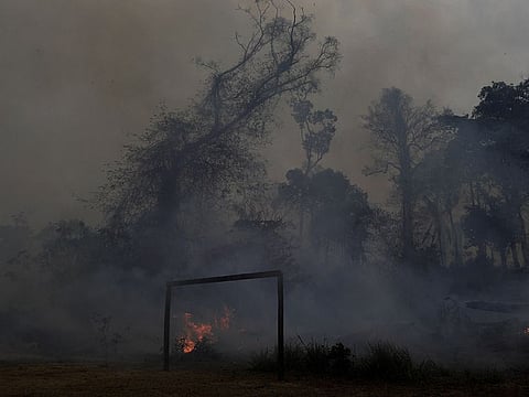 A fire burns a tract of Amazon jungle as it is cleared by loggers and farmers behind a soccer field near Porto Velho, Brazil August 27, 2019.