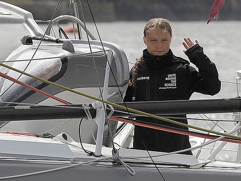 Climate change activist Greta Thunberg waves from the Malizia II boat in Plymouth, England.