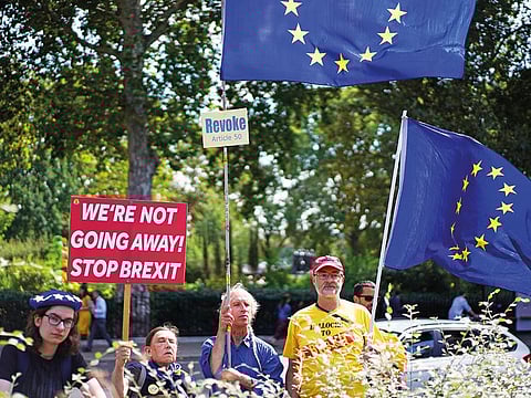 Anti-Brexit protesters hold placards and flags of the European Union outside the Houses of the Parliament in London, Britain.