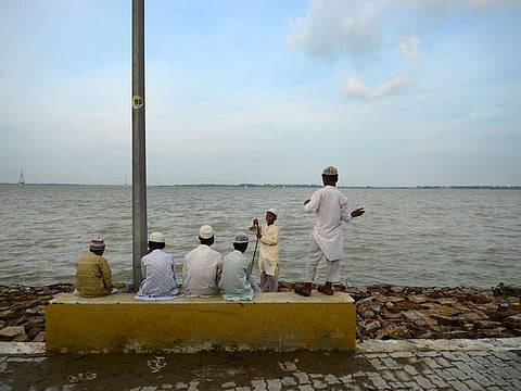 Indian Muslim students of a religious school or Madrasa sit on the bank of river Ganges as flood waters receded at the Sangam area in Allahabad on August 25, 2019