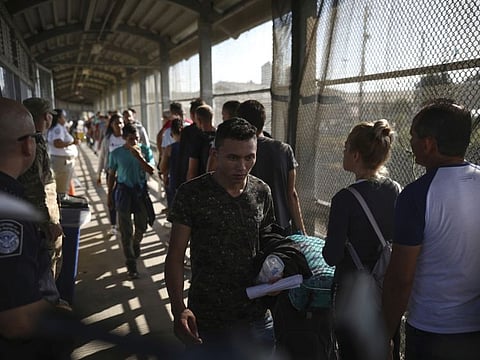 Migrants return to Mexico as 15 other migrants line up on their way to request asylum in the US, at the foot of the Puerta Mexico bridge that crosses to Brownsville, Texas, in Matamoros, Mexico.