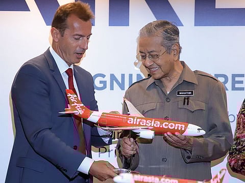 Malaysian Prime Minister Mahathir Mohamad receives a model plane from Airbus Chief Executive Officer Guillaume Faury during the Airbus and AirAsia signing ceremony in Kuala Lumpur on August 30, 2019.