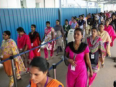 Employees, who have arrived by bus for the afternoon shift, badge in at the mobile phone plant of Rising Stars Mobile India Pvt., a unit of Foxconn Technology Co., in Sri City, Andhra Pradesh, India.