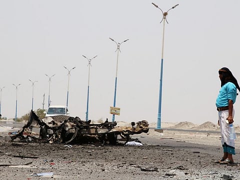 A man stands past the wreckage of government forces vehicles destroyed by UAE air strikes near Aden, Yemen, August 30, 2019.