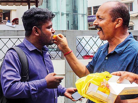 People share sweets after the publication of final draft of National Register of Citizens (NRC) list in Guwahati.