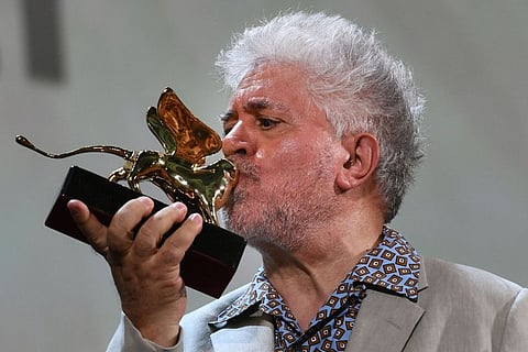 Spanish director Pedro Almodovar kisses his award on August 29, 2019 after receiving a Golden Lion for lifetime achievement during a ceremony at the 76th Venice Film Festival at Venice Lido.