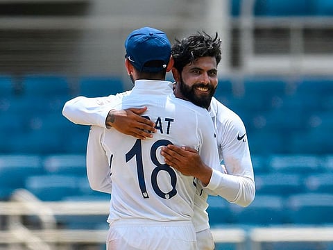 Virat Kohli (L) and Ravindra Jadeja (R) of India hug in celebration of the wicket of Jahmar Hamilton.