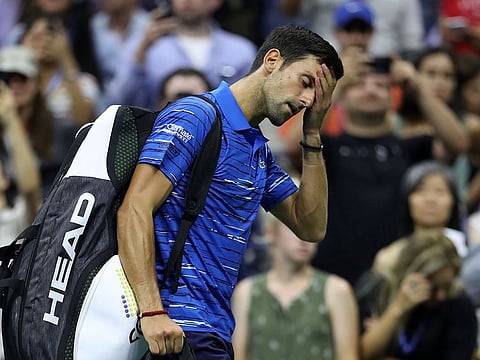 Novak Djokovic of Serbia reacts as he walks off court after retiring due to a should injury during his Men's Singles fourth round match against Stan Wawrinka of Switzerland on day seven of the 2019 US Open