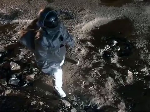 Baadal Nanjundaswamy dressed as an astronaut walking on potholes.