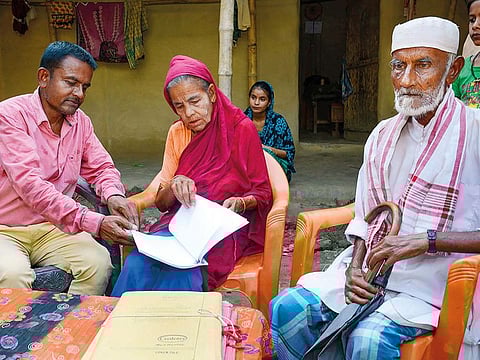 Khaibar Ali, left, along with his father Jahur Ali and mother Sarifa Bebi year old, check the names in the published final list of the National Register of Citizens (NRC), at Gorbhetar village in Baska district of Assam.