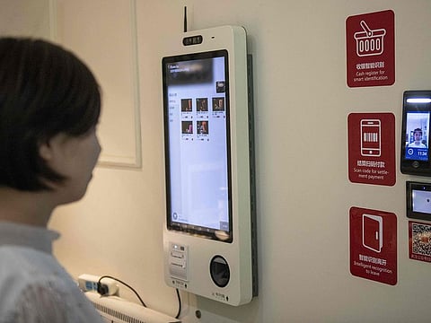 A woman uses a facial recognition device installed at an IFuree Go self-service supermarket in Tianjin