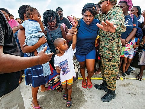 Royal Bahamas Defense Forces and Royal Bahamas Police help evacuees move to an awaiting ferry boat at Marsh Harbour Port in Abaco.
