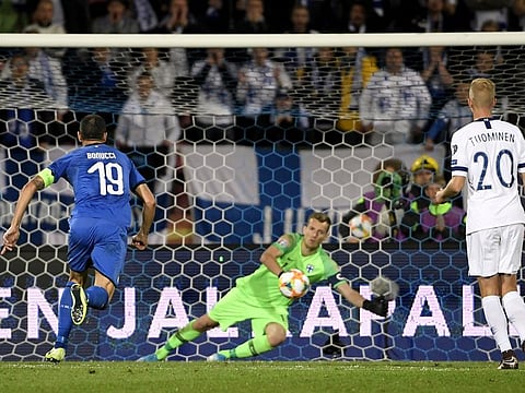 Finland's goalkeeper Lukas Hradecky fails to stop the penalty by Italy's Jorginho.