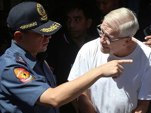 In this Feb. 19, 2019, photo, Philippine National Police, National Capital Region Police Chief Maj. Gen. Guillermo Eleazar, left, talks to Catholic priest Father Pius Hendricks prior to being served five more arrest warrants at the Regional Special Operations Unit at Camp Bagong Diwa in suburban Taguig, east of Manila, Philippines. Investigators say about 20 boys and men, one as young as 7, have accused the priest of sexual abuse at his parish in Talustosan village, Naval township, Biliran province in central Philippines