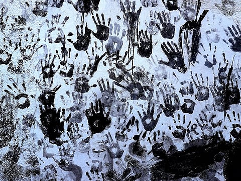Hand prints are made by people painted with black grease on a wall during the traditional festivities of the Cascamorras festival in Baza, Spain.