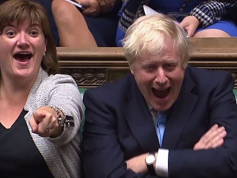 Britain’s Prime Minister Boris Johnson (R) and Culture Secretary Nicky Morgan (L) react as opposition Labour Party Jeremy Corbyn speaks.