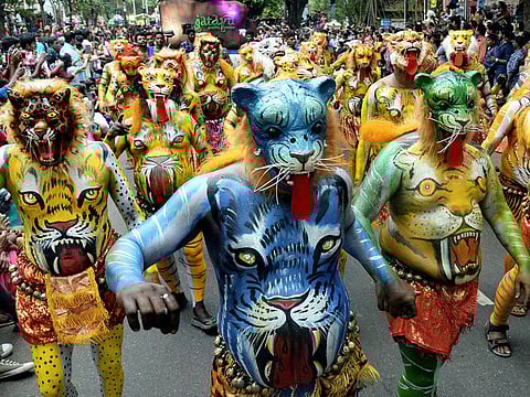 Artists perform pulikali, or tiger dance, during Onam celebrations
