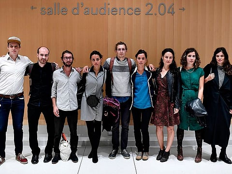 Ecology activists charged with "robbery in collusion" after they removed portraits of French president Emmanuel Macron in several Paris district's cityhalls in February, pose for a family picture before their trial at the courthouse in Paris on September 11, 2019.