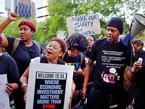 Women hold placards as they protest against gender-based violence, outside the Johannesburg Stock Exchange in Sandton, Johannesburg, South Africa.