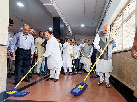 Home Minister Amit Shah (right) and BJP working president J.P. Nadda, along with party leaders Vijay Goel and Vijender Gupta sweep the floor at AIIMS hospital, in New Delhi.