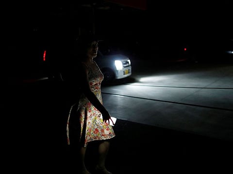 A local resident holding flashlight walks in a blackout caused by Typhoon Faxai in Kisarazu, Chiba prefecture, Japan September 9, 2019.