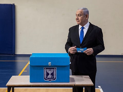 Israeli Prime Minister Benjamin Netanyahu holds his ballot as he votes during parliamentary election at a polling station in occupied Jerusalem on Tuesday.