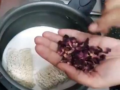 Rose petals being added to maggi noodles in milk.
