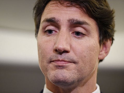 Canadian Prime Minister and Liberal Party leader Justin Trudeau reacts as he makes a statement in regards to a photo coming to light of himself from 2001, wearing "brownface," during a scrum on his campaign plane in Halifax, Nova Scotia, Wednesday, Sept. 18, 2019.